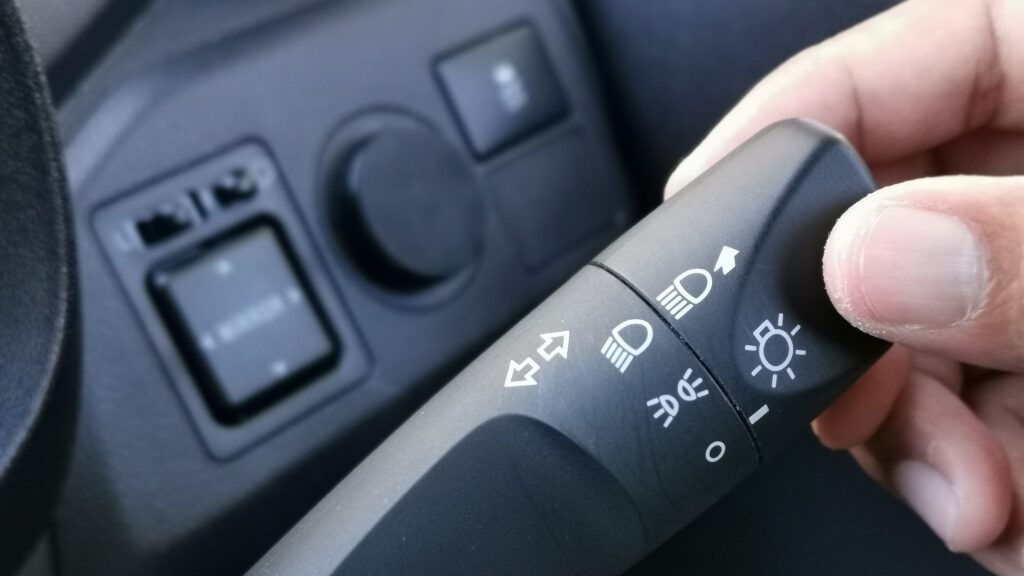 Driver using a turn signal as part of defensive driving to communicate clearly and prevent accidents.