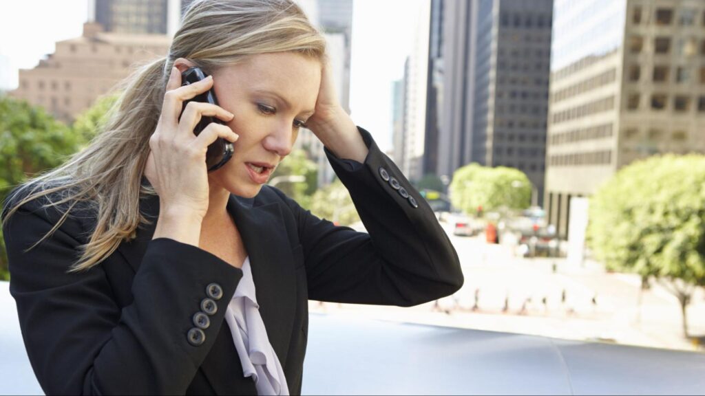 Businesswoman outdoors looking distressed while speaking on her cellphone