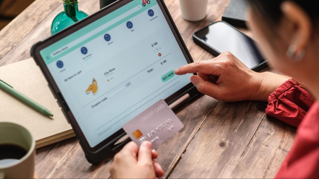 Person using a tablet and credit card for an online payment, symbolizing financial scams and fake lawyer schemes in Florida.