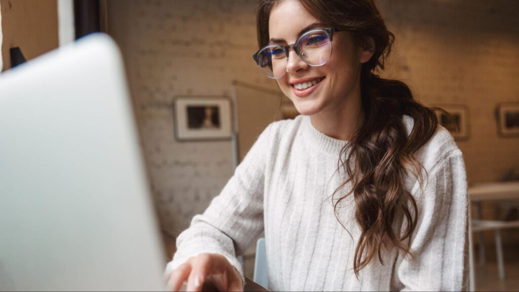 A woman sitting at her laptop verifying a car accident attorney’s credentials online to avoid scams.