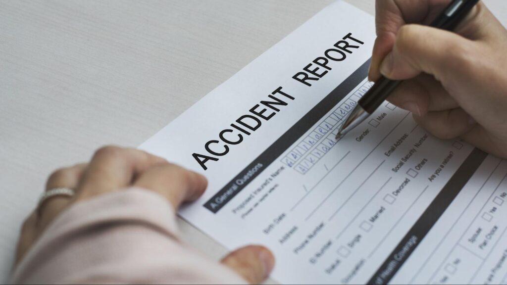Close-up of a person filling out an accident report form after a car accident during the holiday in Florida.