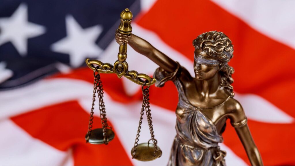 Statue of Lady Justice in front of the American flag symbolizing legal rights for Miami personal injury victims after a car accident.