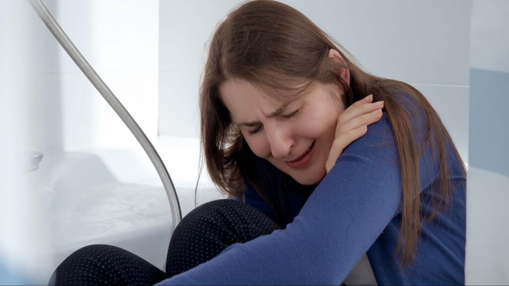 Woman experiencing shoulder pain days after a Florida car accident, showing delayed injury symptoms