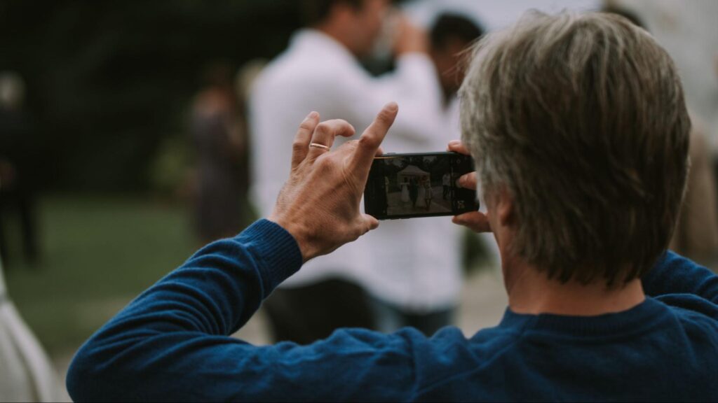 A witness using a smartphone to record an accident scene, highlighting how witness statements and evidence can impact Florida car accident claims.